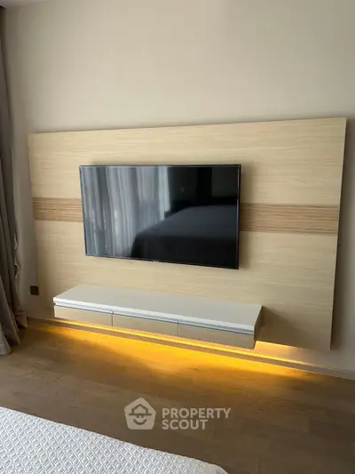 Modern bedroom with sleek wall-mounted TV and ambient lighting