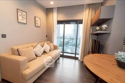 Modern living room with city view, cozy beige sofa, and elegant decor.