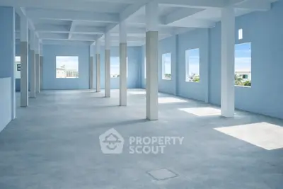 Spacious open-plan interior with large windows and abundant natural light, ideal for versatile real estate opportunities.