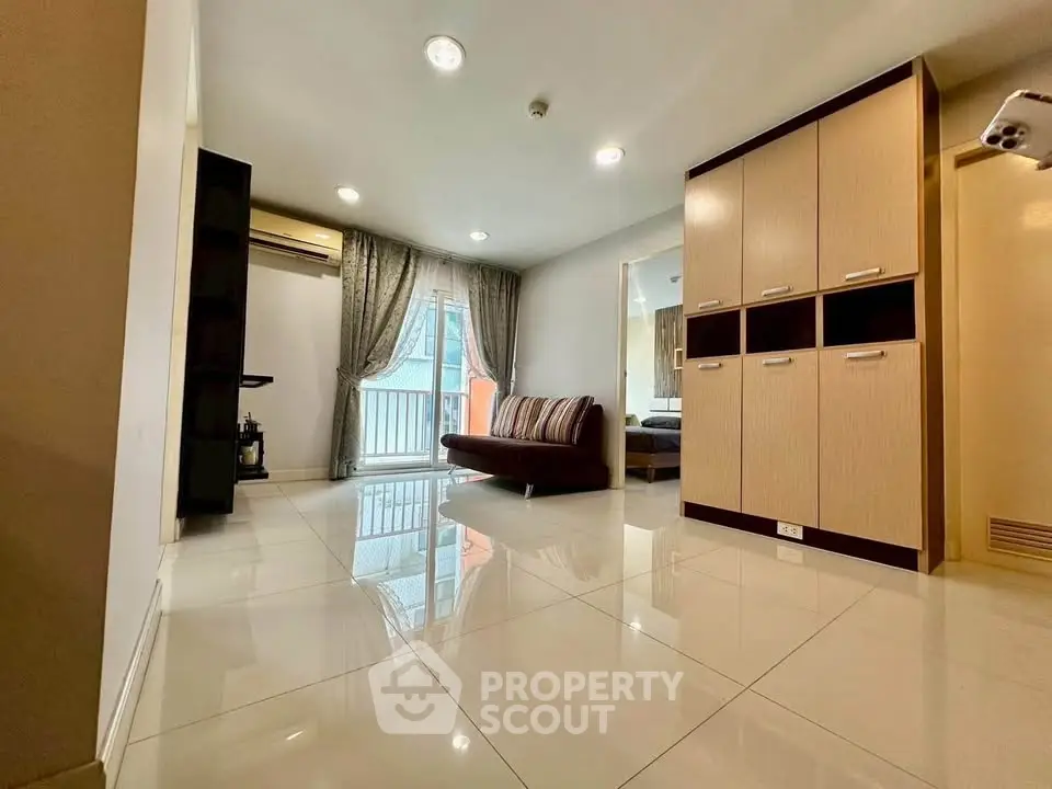 Spacious modern living room with sleek tile flooring and cozy seating area.