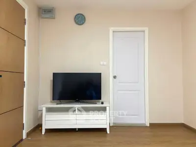 Modern living room with sleek TV stand and wall-mounted clock, showcasing minimalist design.