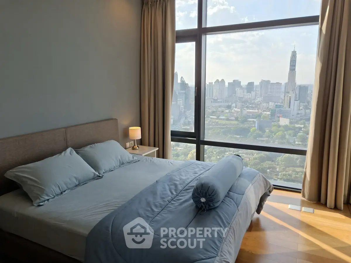 Luxurious bedroom with stunning city view from floor-to-ceiling windows, featuring elegant bedding and ambient lighting.