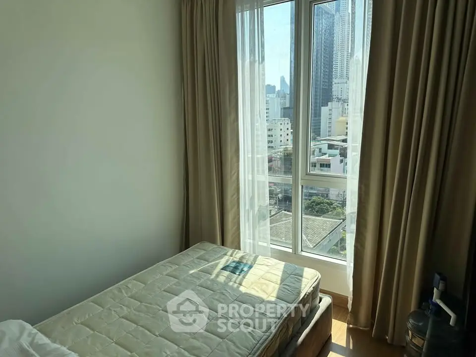 Bright bedroom with city view and large windows in modern apartment