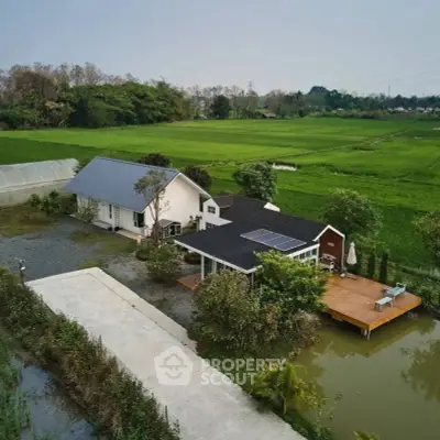 Charming countryside home with solar panels and lush green surroundings.