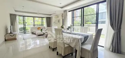 Spacious modern living and dining area with large windows and garden view