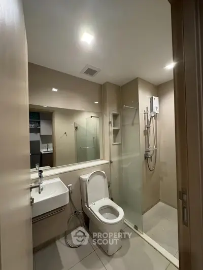 Modern bathroom with glass shower and sleek fixtures in a contemporary apartment.