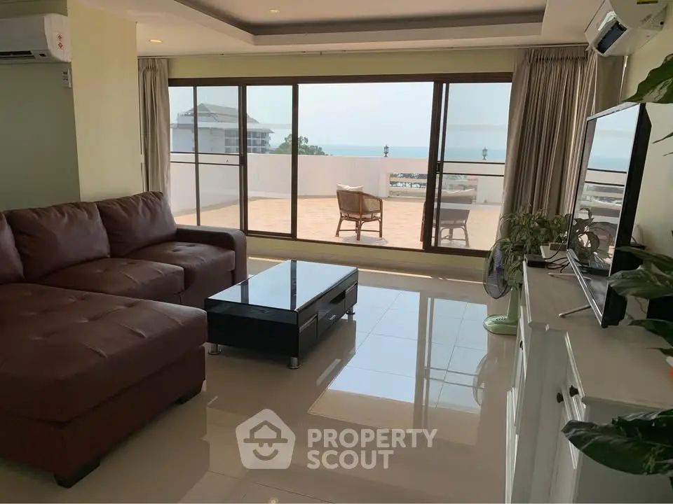 Spacious living room with ocean view and large balcony access.