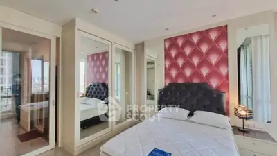 Luxurious bedroom with elegant decor and mirrored wardrobe in modern apartment.