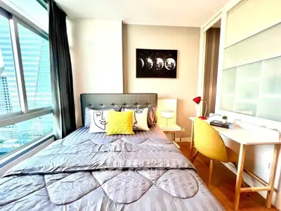 Modern bedroom with city view, stylish decor, and natural light