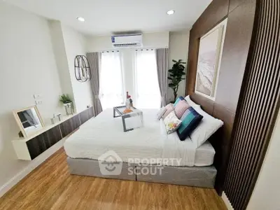 Modern bedroom with stylish decor and natural light, featuring cozy bedding and elegant wall art.