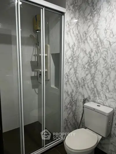Modern bathroom with sleek shower and marble-patterned walls