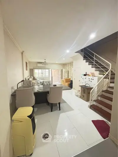 Spacious living room with elegant dining area and staircase in modern home