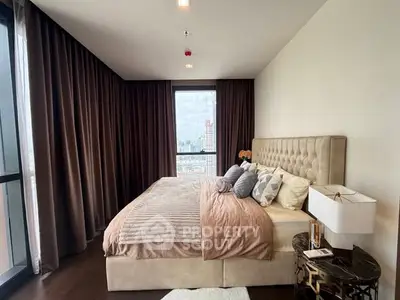 Luxurious bedroom with plush bedding and city view in modern apartment.