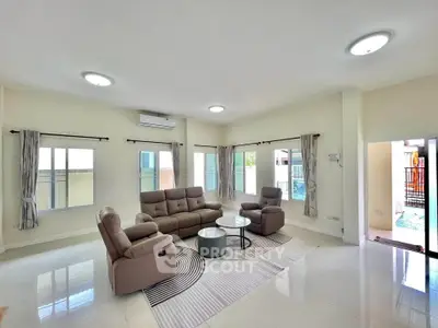 Spacious living room with modern furniture and ample natural light in a stylish home.