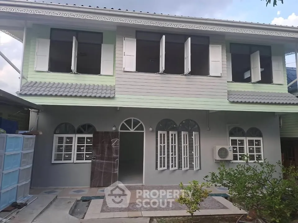 Charming two-story house with unique architectural design and lush garden, perfect for family living.