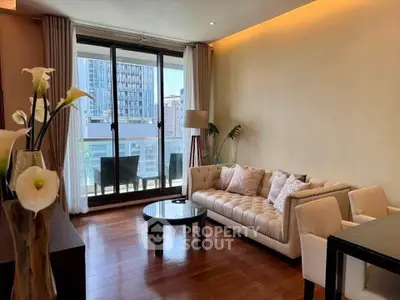 Elegant living room with modern furniture and balcony view in urban apartment.