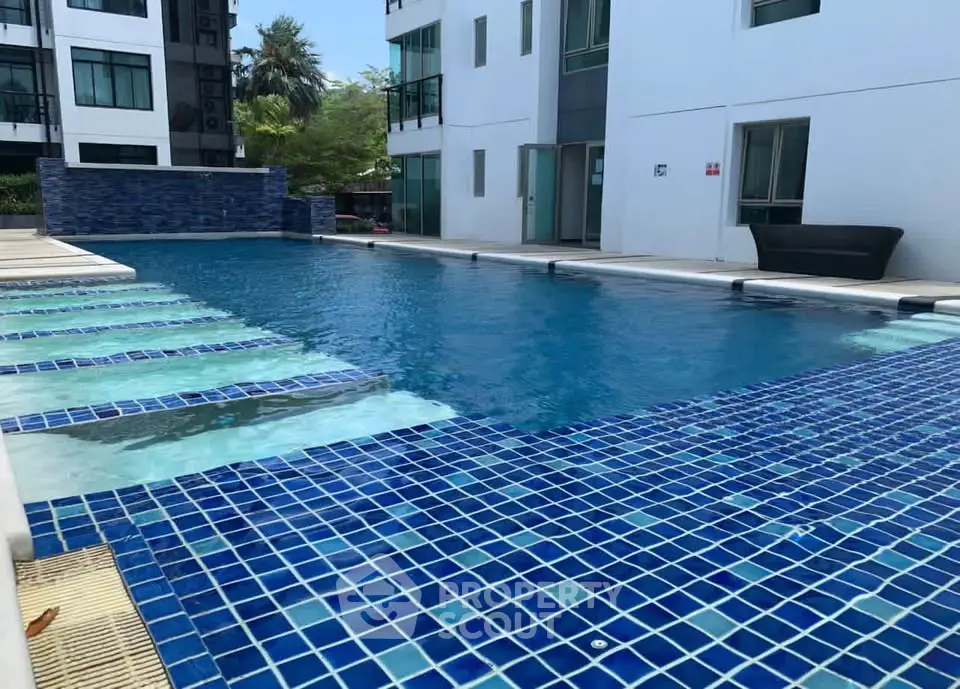 Luxurious apartment complex with a stunning outdoor pool and modern architecture.