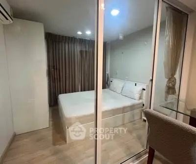 Cozy bedroom with glass partition, modern decor, and ample natural light.