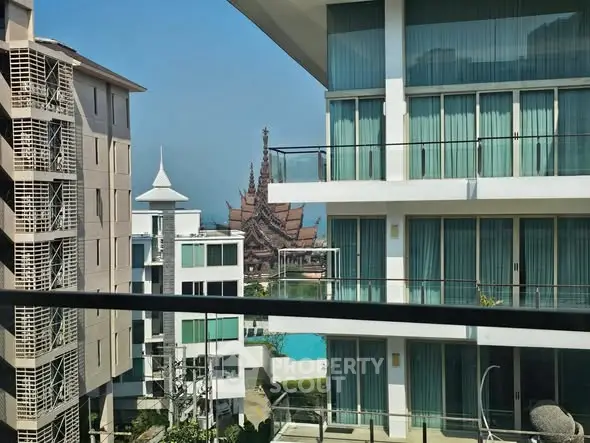 Stunning view from modern balcony overlooking serene pool and architectural landmark.