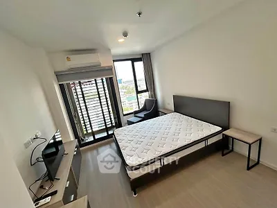 Modern bedroom with large window and minimalist furniture, offering a bright and airy atmosphere.