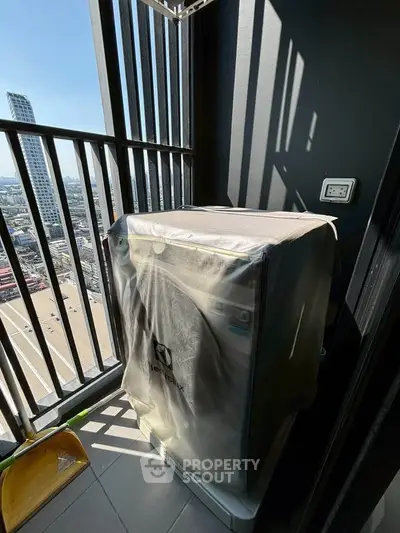 High-rise balcony with city view and covered washing machine