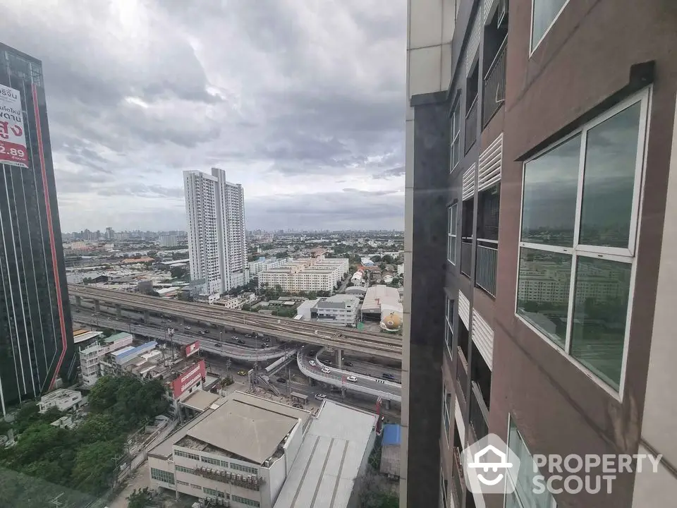 Stunning cityscape view from high-rise apartment window showcasing urban skyline and highways.