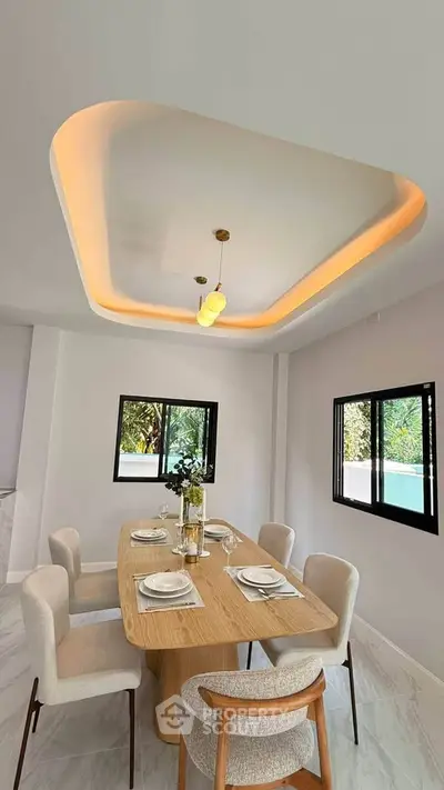 Modern dining room with elegant lighting and stylish furniture, perfect for entertaining guests.