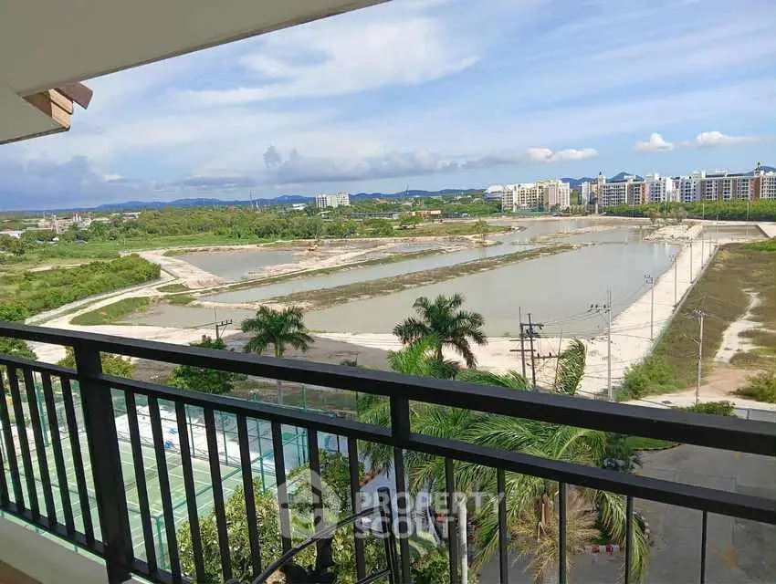 Stunning balcony view overlooking lush greenery and distant cityscape.