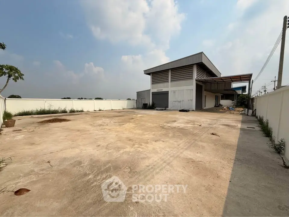 Spacious industrial property with large open yard and modern warehouse building.