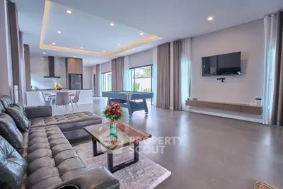 Spacious modern living room with open kitchen and pool table, perfect for entertaining.