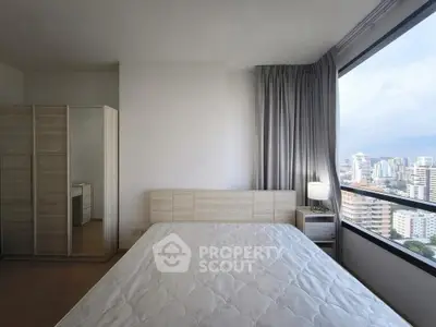 Modern bedroom with large window offering stunning city view, featuring sleek furniture and ample natural light.