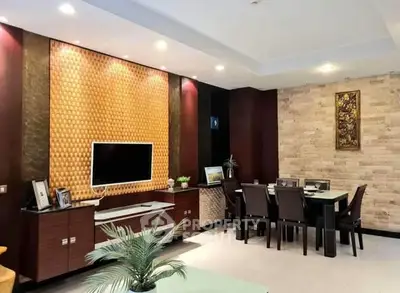 Elegant living room with modern decor and dining area, featuring a stylish TV wall and ambient lighting.
