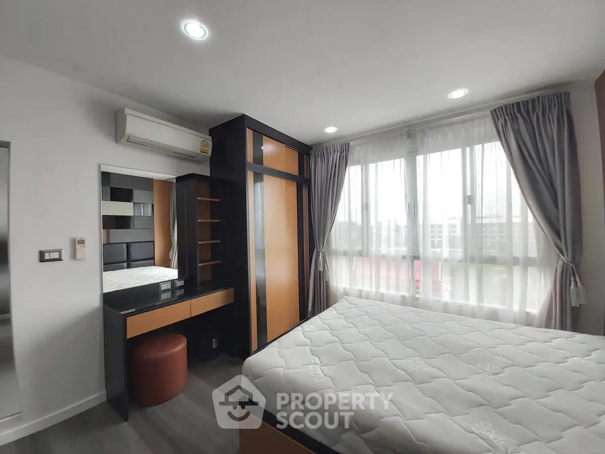 Modern bedroom with large window and stylish furniture in a bright apartment