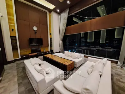 Luxurious high-ceiling living room with modern decor and city view.