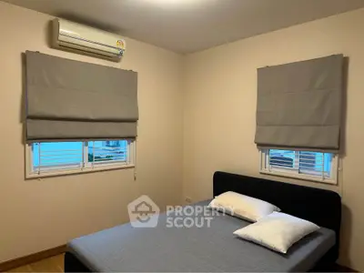 Cozy bedroom with modern air conditioning and stylish window blinds, perfect for relaxation.