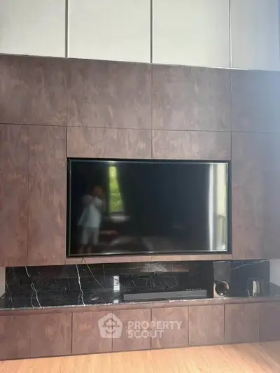 Luxurious living room with modern entertainment center and sleek wood paneling.