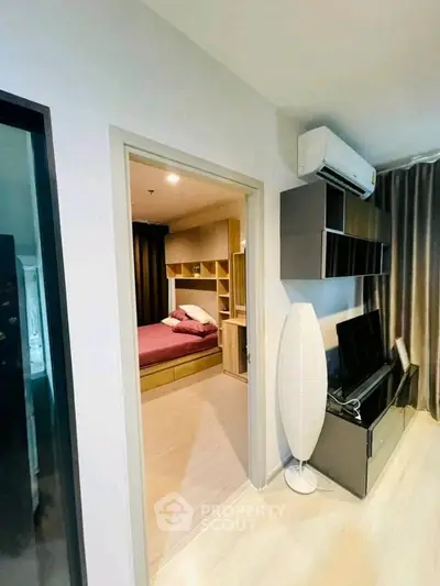 Modern apartment interior with cozy bedroom and stylish living area featuring air conditioning and sleek furniture.