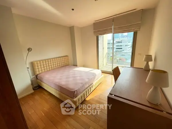 Bright and cozy bedroom with wooden flooring and large window view