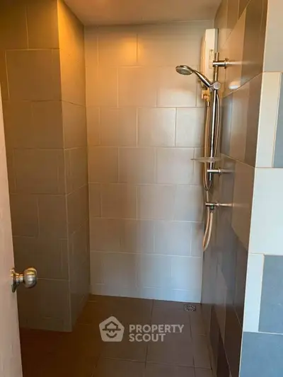 Modern bathroom with sleek shower fixtures and tiled walls, perfect for a contemporary home.