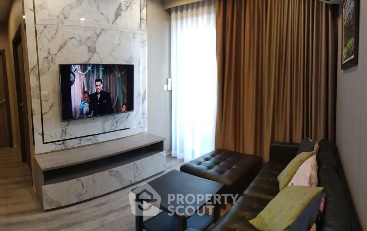 Modern living room with marble accent wall and TV, cozy seating area.