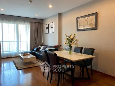 Elegant living room with dining area, hardwood floors, and stylish decor in modern apartment.