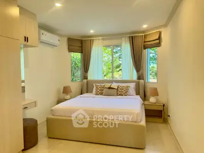 Spacious and bright bedroom with modern decor and large windows offering a serene view.