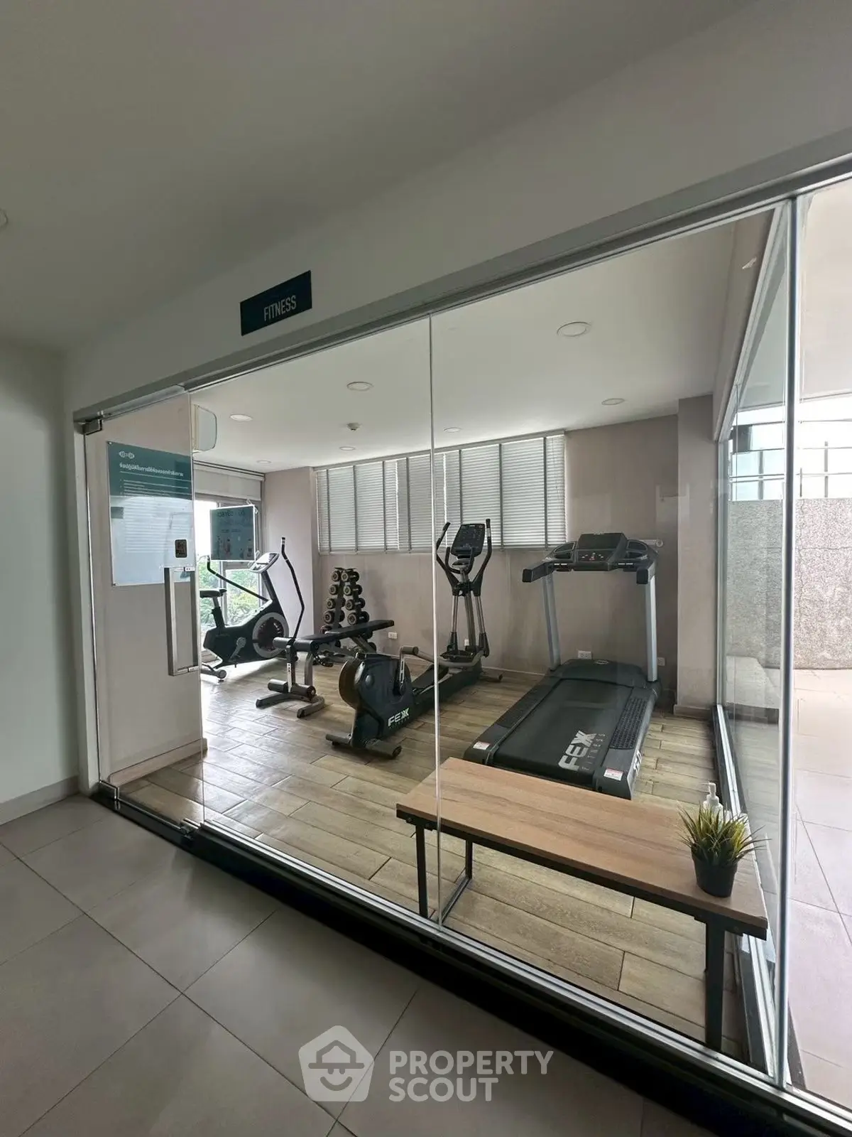 Modern gym with glass walls and fitness equipment in a residential building