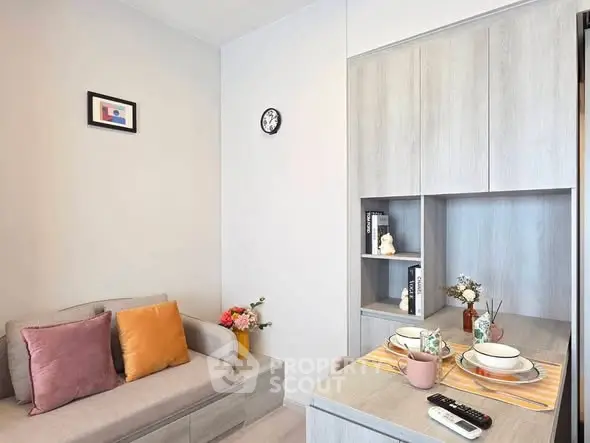 Modern living room with cozy sofa and stylish decor in a compact apartment.