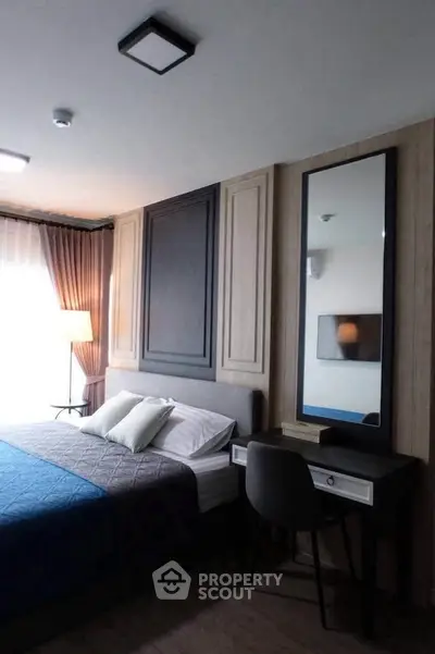 Elegant bedroom with modern decor and stylish furnishings, featuring a cozy bed and a sleek vanity mirror.