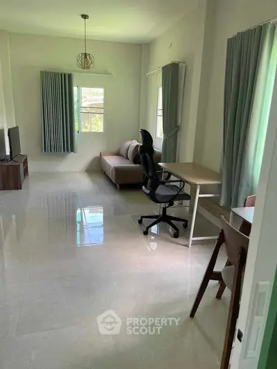 Spacious living room with modern furniture and natural light, perfect for relaxation and productivity.