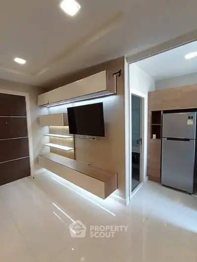 Modern living room with sleek TV unit and adjacent kitchen area