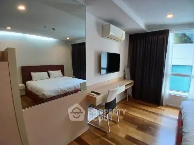 Modern bedroom with wooden flooring, wall-mounted TV, and large window with curtains.