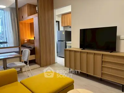 Modern living room with stylish furniture and open kitchen layout, featuring a cozy bedroom nook.
