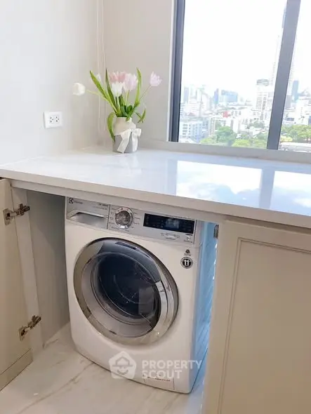 Modern laundry area with built-in washing machine and city view